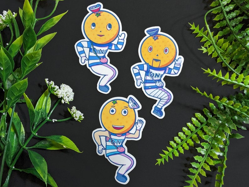 May include: Three cartoon orange stickers with blue and white striped outfits. Each orange has a face and is wearing a hat. The oranges are on a black background.