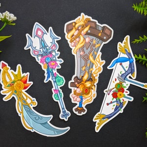 May include: Four colourful fantasy weapon stickers with floral details. The stickers feature a trident, a sword, a bow and arrow, and a dagger.