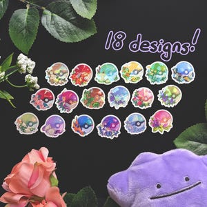 May include: A collection of 18 colorful sticker designs featuring floral and character-themed illustrations. The stickers are arranged on a black surface, surrounded by greenery and flowers, with a purple plush toy in the corner. The text "18 designs!" is also visible.