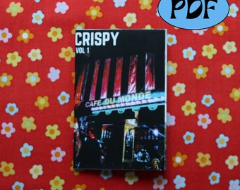 May include: A black and white photo of a cafe with red and white striped awning. The cafe is called "Cafe du Monde". The text "CRISPY VOL 1" is at the top of the image.