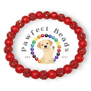 Peut inclure: Bracelet rouge en perles avec des accents scintillants. Le bracelet est composé de perles rondes avec une finition brillante. Les perles sont entrecoupées de perles plus petites et scintillantes. Le bracelet est un accessoire populaire pour les amoureux des chiens.