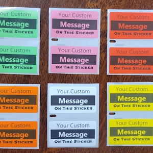May include: Eight sticker sheets with a customizable message. Each sheet has two stickers with a white background and black text. The text on the stickers reads "Your Custom Message ON THIS STICKER". The stickers are in different colors: green, pink, orange, yellow, brown, and white.