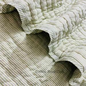 Green stripe cotton quilt draped over sofa or bed, reversible design, soft breathable cotton, handcrafted kantha stitching, perfect for boho, farmhouse, or Indian-inspired décor accents. Flat-lay image of reversible green stripe Kantha quilt, highlighting 100% cotton fabric, hand block printed stripes, lightweight yet cozy, ideal for King or Queen bedspread, throw, or décor gift.