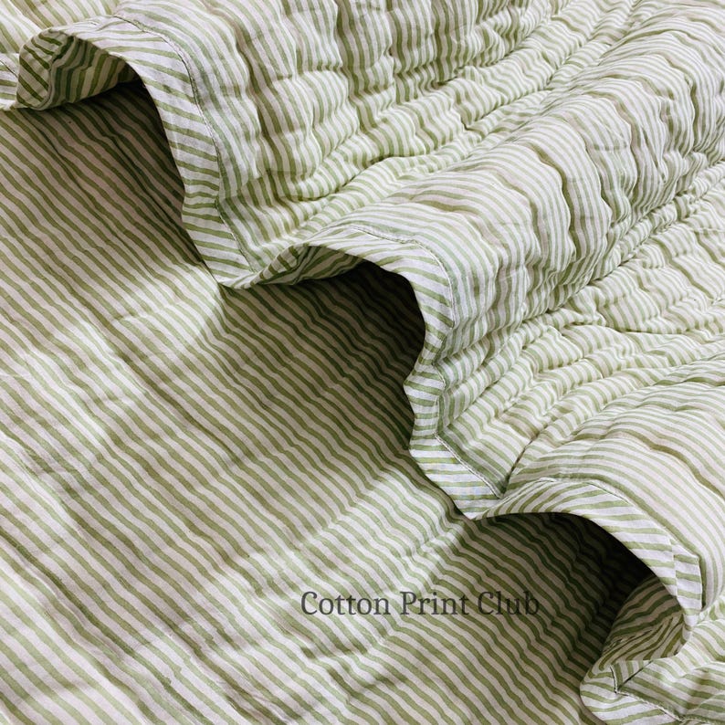 Green stripe cotton quilt draped over sofa or bed, reversible design, soft breathable cotton, handcrafted kantha stitching, perfect for boho, farmhouse, or Indian-inspired décor accents. Flat-lay image of reversible green stripe Kantha quilt, highlighting 100% cotton fabric, hand block printed stripes, lightweight yet cozy, ideal for King or Queen bedspread, throw, or décor gift.
