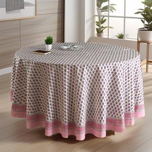 May include: White round tablecloth with a pink and blue floral pattern. The tablecloth has a pink border with a white stripe.