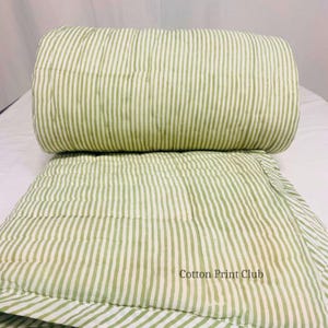 Detailed shot of kantha quilt stitching, highlighting green stripe pattern, soft breathable cotton, reversible design, combining Indian traditional handwork with modern farmhouse style. King-size Kantha bedspread with green stripes, reversible cotton quilt, showcasing lightweight comfort, timeless boho design, perfect for layering, bedroom décor, or home photography.