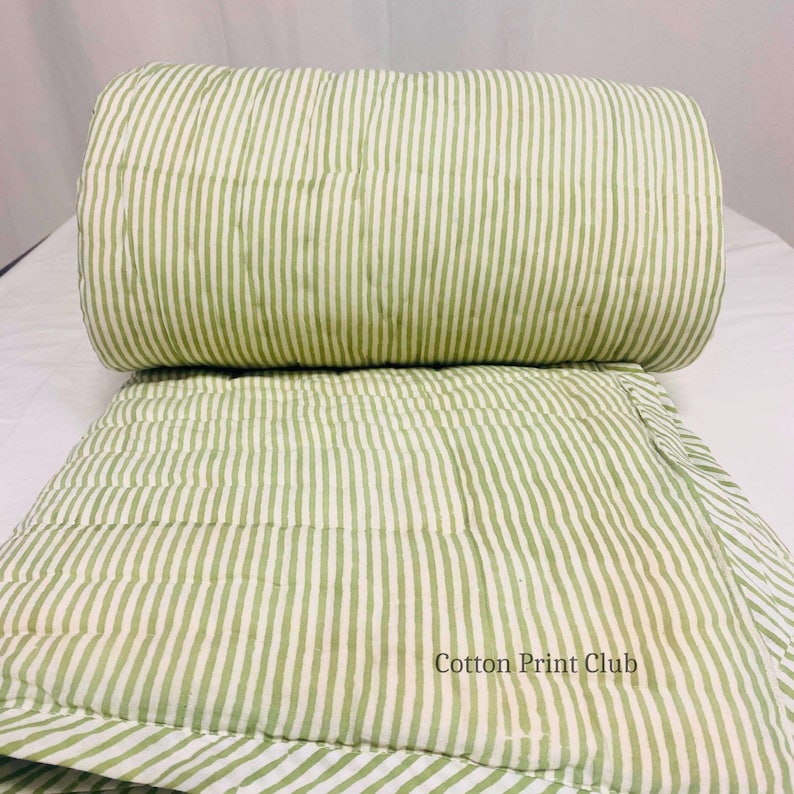 Detailed shot of kantha quilt stitching, highlighting green stripe pattern, soft breathable cotton, reversible design, combining Indian traditional handwork with modern farmhouse style. King-size Kantha bedspread with green stripes, reversible cotton quilt, showcasing lightweight comfort, timeless boho design, perfect for layering, bedroom décor, or home photography.