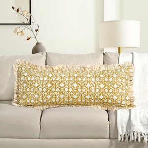 Op de afbeelding: Een rechthoekig decoratief kussen met een geel en wit bloemenpatroon. Het kussen heeft een gerimpelde rand en ligt op een beige bank. Het patroon is een herhalend bloemmotief, dat een vleugje elegantie aan de woondecoratie toevoegt.