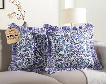 May include: Two square throw pillows with a floral pattern in shades of blue and white. The pillows have ruffled edges with a blue and white striped design. A tag reads "Cotton Print Club 2 Packs 100% Cotton."