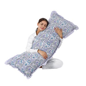 May include: A large, rectangular body pillow with a floral pattern in shades of blue, purple, and white. The pillow has a ruffled edge and is designed for comfort and support. The pillow is approximately 50 inches long.