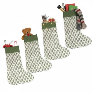 Peut inclure: Quatre bas de Noël avec un motif floral blanc et vert. Chaque bas a un revers vert et est rempli de cadeaux, dont un ours en peluche, une voiture jouet, un sucre d'orge, une bouteille de champagne et des cadeaux emballés.