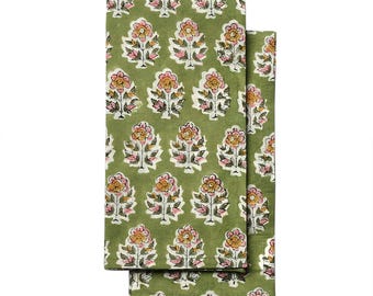 May include: Two folded green cloth napkins with a repeating floral pattern. The flowers are in shades of pink, yellow, and white. The napkins are a soft, muted green color. The floral design is a block print style.