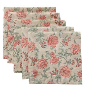 May include: A stack of six square cloth napkins. Each napkin features a repeating floral pattern of large coral-colored roses and green leaves on a cream-colored background. The napkins are neatly folded and stacked.