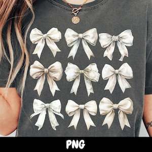 May include: A dark gray t-shirt with a design of 12 white watercolor bows. The bows are arranged in four rows of three. The shirt has the word "PNG" printed on the bottom.