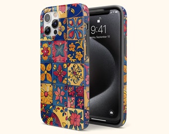 Op de afbeelding: Een kleurrijke telefoonhoes met een patroon van blauwe, gele, rode en groene tegels met bloemmotieven. De hoes is ontworpen voor een iPhone met een camerabult.