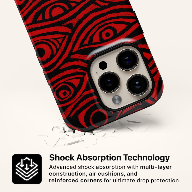 Puede incluir: Una funda de tel&eacute;fono negra y roja con un patr&oacute;n similar a un ojo. La funda tiene un acabado brillante y presenta un recorte para la c&aacute;mara. La imagen tambi&eacute;n incluye el texto "Shock Absorption Technology" y detalles sobre las caracter&iacute;sticas de protecci&oacute;n de la funda.