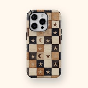 Może przedstawiać: Etui na telefon z szachownicą z kwadratów w odcieniach brązu, czerni i kremu. Kwadraty przedstawiają gwiazdy i kształty półksiężyca. Etui ma błyszczące wykończenie i wycięcie na aparat.
