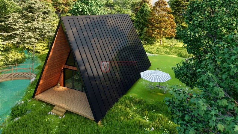 May include: An A-frame cabin featuring a dark metal roof, natural wood siding on the front gable, and a wooden deck. The structure includes large glass windows and doors, positioned near a small stream with a wooden bridge and a striped umbrella.