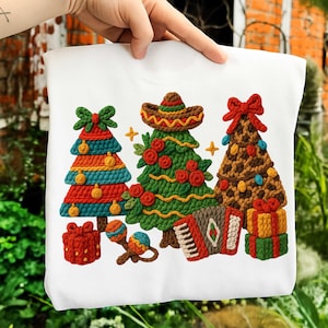 May include: White sweatshirt featuring a colorful embroidered design of three Christmas trees, a sombrero, maracas, an accordion, and wrapped gifts. The trees are decorated with bows, ornaments, and roses. A festive holiday theme.