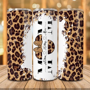 Op de afbeelding: Een witte tumbler met een luipaardprint en de tekst "I Love Mom" met een hart en strik. De tekst "Victoria Henry Alex" staat onder het hart.