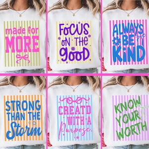May include: White sweatshirts with colorful text designs. The designs include phrases like "Made for More," "Focus on the Good," "Always Be Kind," "Strong Than the Storm," "Created with a Purpose," and "Know Your Worth."