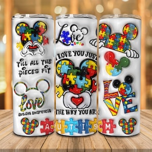 May include: Three white stainless steel tumblers with a Mickey Mouse theme. The tumblers feature a colorful puzzle piece design and the text "Love You Just The Way You Are", "Till All The Pieces Fit", and "Love Autism Awareness".