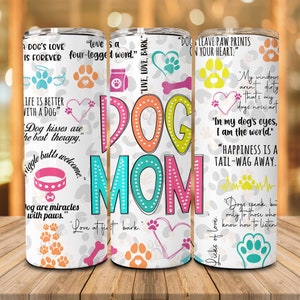 May include: White tumbler with a colorful "Dog Mom" design and paw prints. The tumbler features quotes about dogs, including "A dog's love is forever" and "Happiness is a tail-wag away."