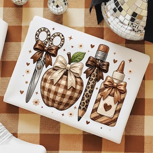 May include: A white rectangular item featuring a graphic print of school supplies including leopard print scissors with a brown bow, a plaid apple with a cream bow, a leopard print pencil with a brown bow, and a glue bottle with a brown bow and heart.