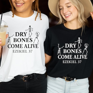 May include: Two t-shirts, one white and one black, each with the text "DRY BONES COME ALIVE" and "EZEKIEL 37" in black. The shirts also feature a skeleton graphic. The models are wearing black pants.