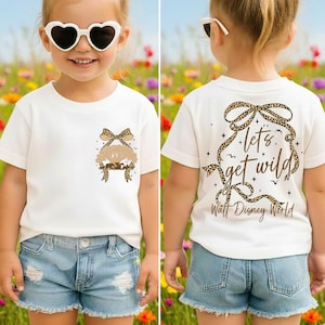 May include: White t-shirt with a leopard print bow and a tree design. The back of the shirt features the text "let's get wild" and "Walt Disney World" in a decorative leopard print frame.