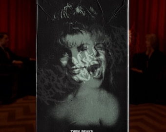 Może przedstawiać: Czarno-biały plakat z efektem postarzenia, przedstawiający twarz kobiety nałożoną na upiorny obraz. U dołu napis "TWIN PEAKS". Tło przedstawia czerwone zasłony i rozmyte postacie, tworząc tajemniczą atmosferę.