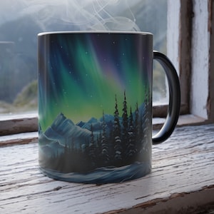 May include: A black coffee mug with a colorful aurora borealis scene and a snowy mountain range. Steam rises from the mug.