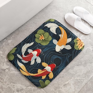 May include: A dark blue bath mat with a colourful koi fish design. The mat features three koi fish swimming in a pond with lily pads and swirling water patterns.
