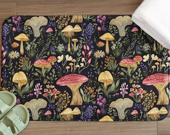 Könnte beinhalten: Eine rechteckige Badematte mit dunklem Hintergrund und einem farbenfrohen Pilz- und Blumenmuster. Die Pilze sind in Rot-, Gelb- und Beigetönen gehalten, mit verschiedenen Blumen und Grünzeug. Ein Paar hellgrüne Sandalen ist sichtbar.
