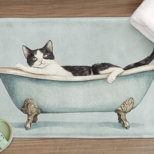 Peut inclure: Un chat noir et blanc se relaxant dans une baignoire bleue sur un tapis de bain bleu clair.