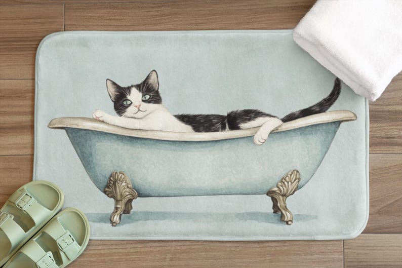 Peut inclure: Un chat noir et blanc se relaxant dans une baignoire bleue sur un tapis de bain bleu clair.