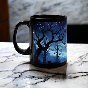 May include: Black ceramic mug with a starry night scene featuring a silhouette of trees. The mug has a white handle.