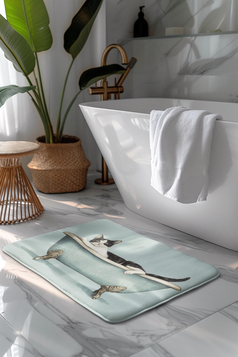 Peut inclure: Un tapis de bain bleu clair avec un chat noir et blanc dans une baignoire. Le chat est allong&eacute; dans la baignoire, la t&ecirc;te pos&eacute;e sur le bord. La baignoire a des pieds dor&eacute;s.