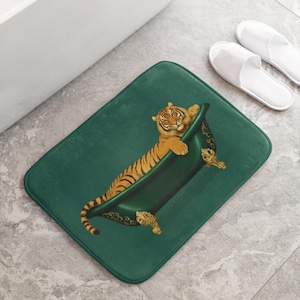 Peut inclure: Tapis de bain rectangulaire vert émeraude avec un tigre se relaxant dans une baignoire vintage. Le tigre a des rayures orange et noires. La baignoire a des détails dorés. Des pantoufles blanches sont à côté du tapis.