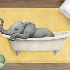 Könnte beinhalten: Eine gelbe Badematte mit einer Cartoon-Illustration eines Elefanten, der in einer weißen Badewanne ein Bad nimmt. Der Elefant ist grau und hat die Augen geschlossen.