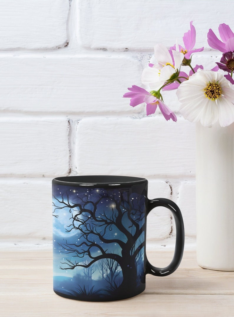 May include: Black ceramic mug with a dark blue and white design of a silhouetted tree with a full moon and stars in the background.
