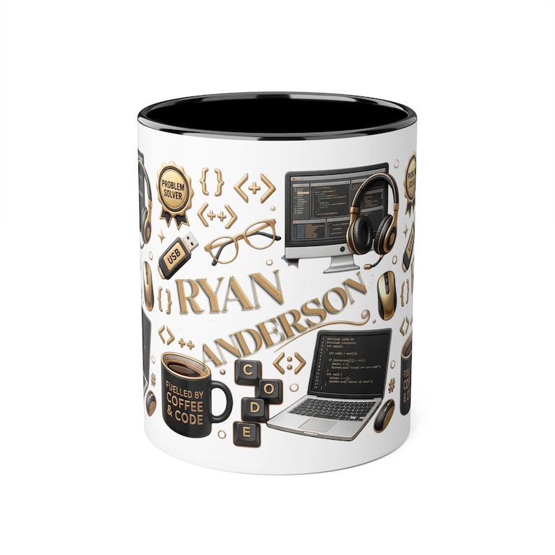 May include: A white ceramic mug with a black interior featuring a gold and black graphic pattern of computer equipment, glasses, code brackets, and the name RYAN ANDERSON. A small black mug with the text FUELLED BY COFFEE & CODE is also visible.