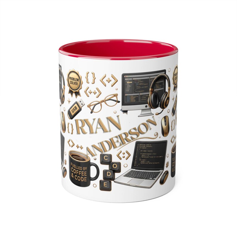 May include: A white ceramic mug with a bright red interior featuring a graphic pattern of gold and black computer-themed icons, including a laptop, monitor, headphones, glasses, and keyboard keys. The name RYAN ANDERSON is printed in gold.