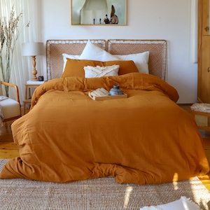 Muslin duvet cover set displayed on bed with decorative pillows, natural light bedroom setting