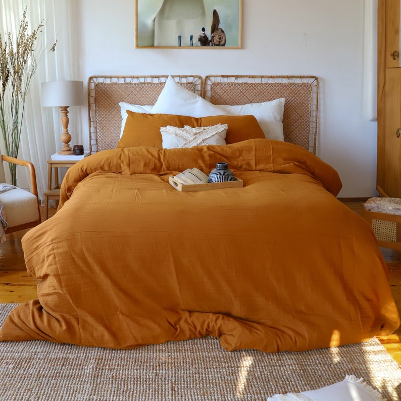 Muslin duvet cover set displayed on bed with decorative pillows, natural light bedroom setting