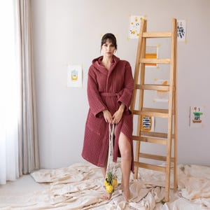 Model in the dark red waffle housecoat standing by a ladder with lemons – elegant cotton waffle housecoat