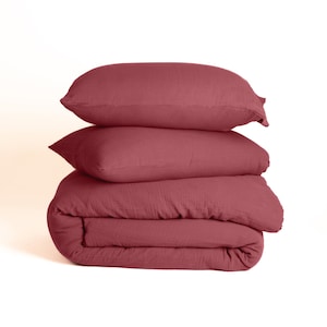 Burgundy muslin duvet cover set on wooden bed frame, cozy bedroom lifestyle with morning light