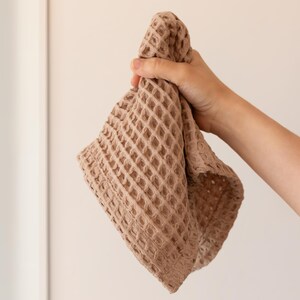 Hand holding soft soft waffle washcloth showing honeycomb texture — waffle face towel washcloth in OEKO-TEX Turkish cotton