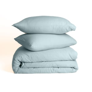 Muslin duvet cover set with two pillowcases laid flat showing complete set contents