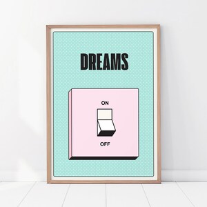 Könnte beinhalten: Ein gerahmter Kunstdruck mit hellblauem Hintergrund und dem Wort "DREAMS" in Schwarz. Darunter befindet sich eine rosa Lichtschaltergrafik mit der Aufschrift "ON" und "OFF". Das Kunstwerk ist in einem Holzrahmen eingefasst.
